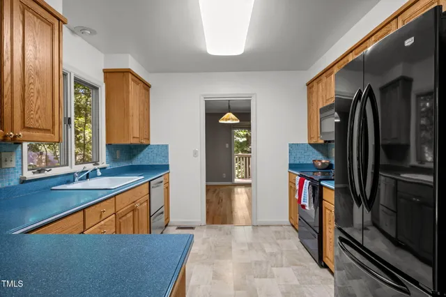 a kitchen with stainless steel appliances granite countertop a refrigerator and a sink