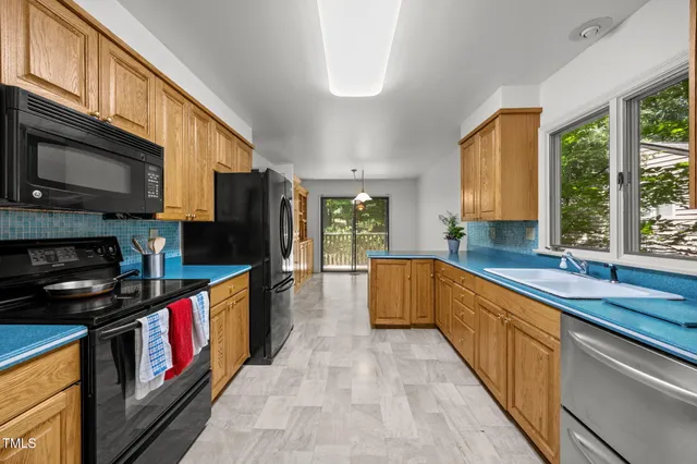 a kitchen with stainless steel appliances granite countertop a sink a stove and a refrigerator