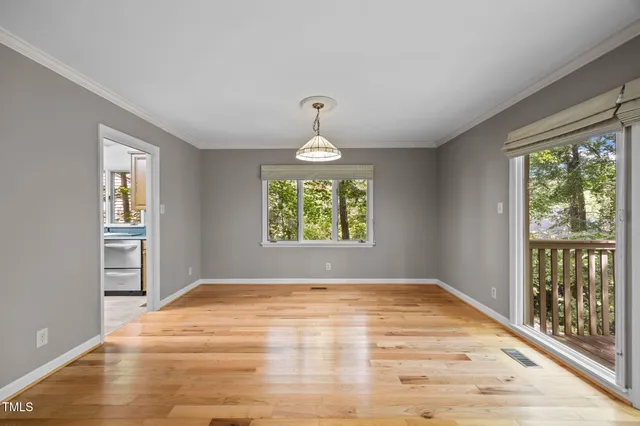 a view of empty room with wooden floor