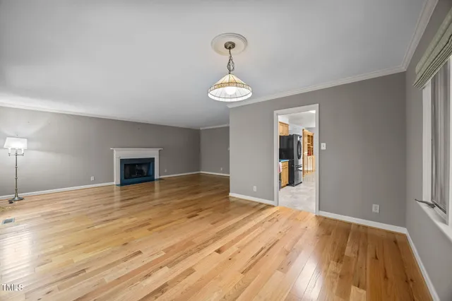a view of an empty room and window and wooden floor
