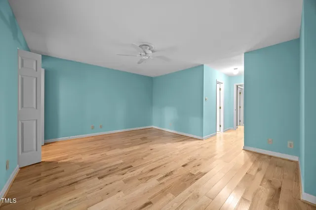 a view of hallway with walk in closet and wooden floor