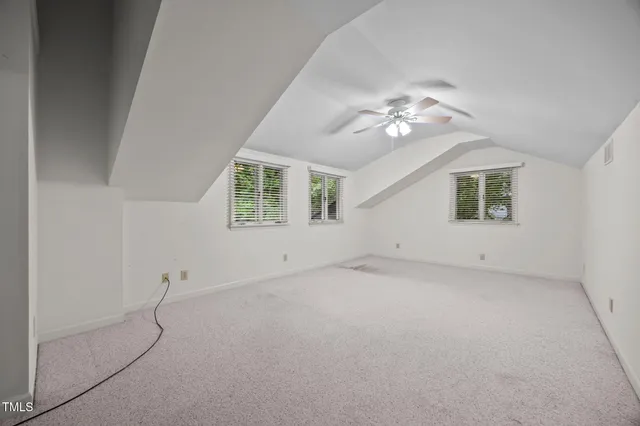an empty room with closet and a ceiling fan
