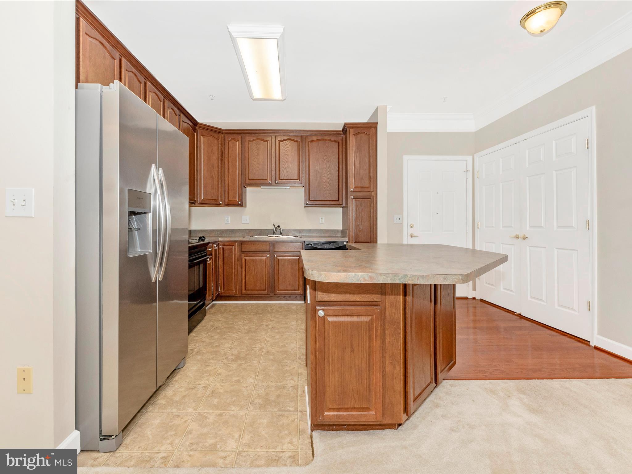 120 Burgess Hill Way, Unit 207 Frederick, MD 21702 - Photo 15 of 67 a kitchen with stainless steel appliances granite countertop a refrigerator and a stove top oven