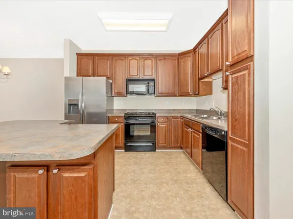 a kitchen with granite countertop a stove top oven microwave and cabinets