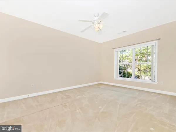 an empty room with a chandelier fan and closet