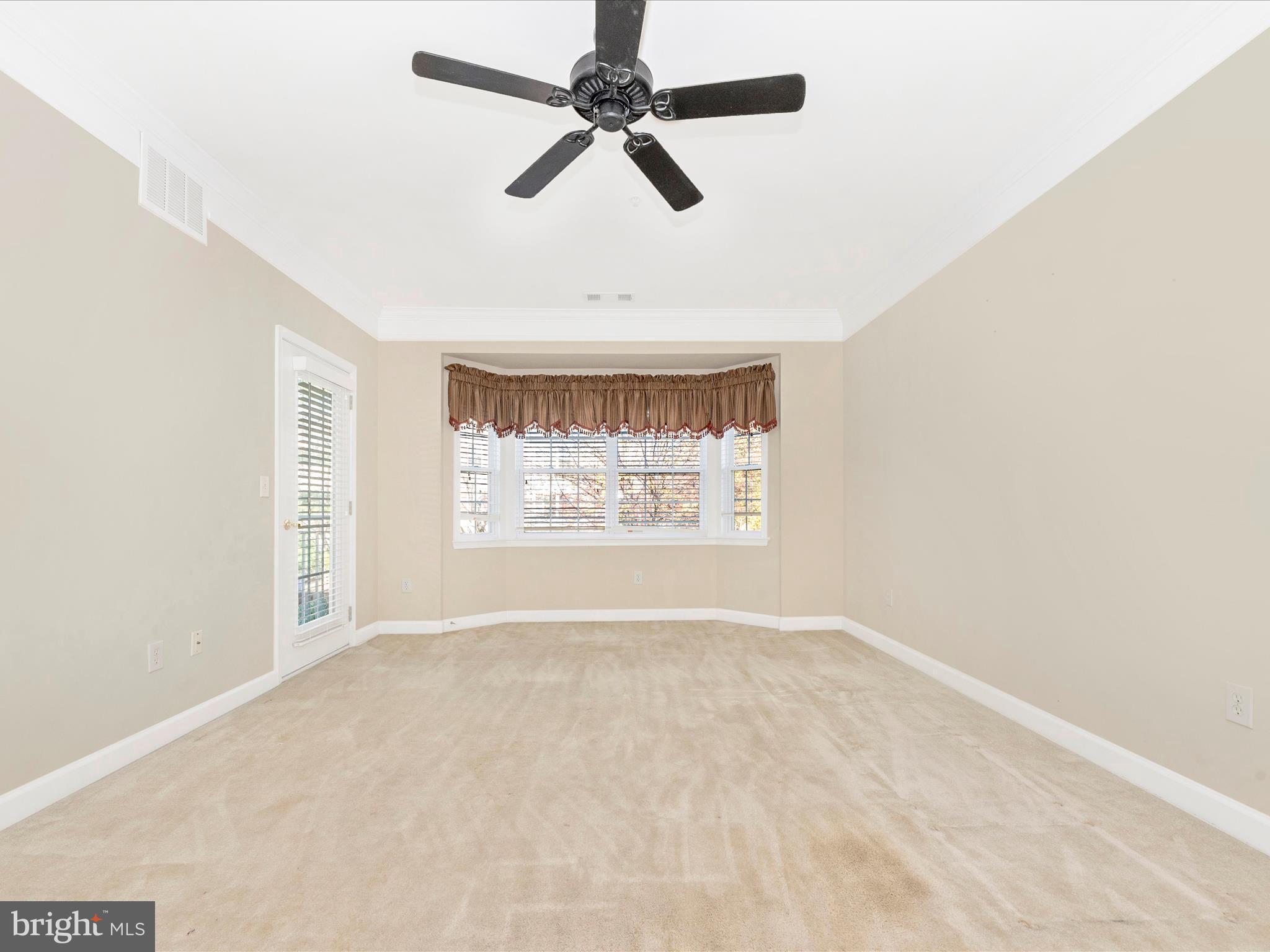 120 Burgess Hill Way, Unit 207 Frederick, MD 21702 - Photo 6 of 67 an empty room with windows and fan