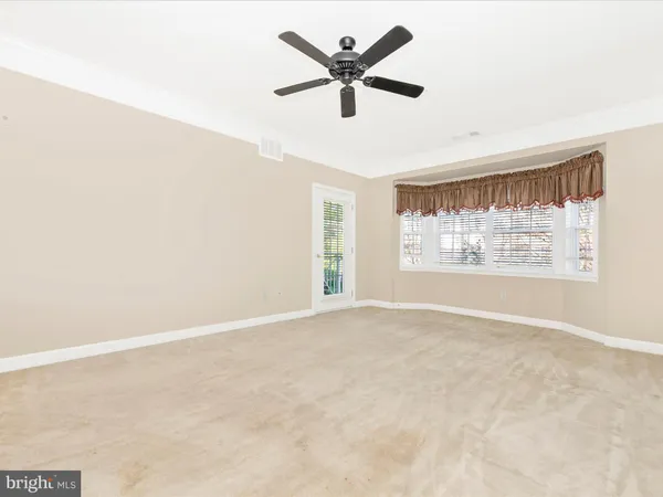 a view of empty room with wooden floor and window