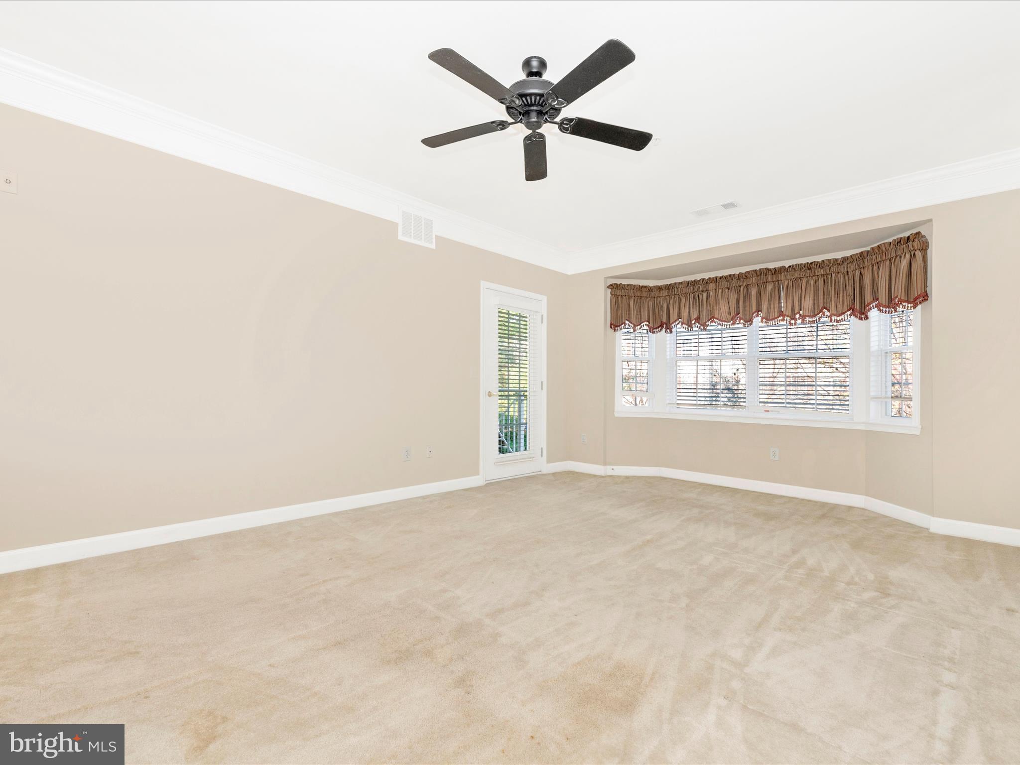 120 Burgess Hill Way, Unit 207 Frederick, MD 21702 - Photo 7 of 67 an empty room with windows and ceiling fan