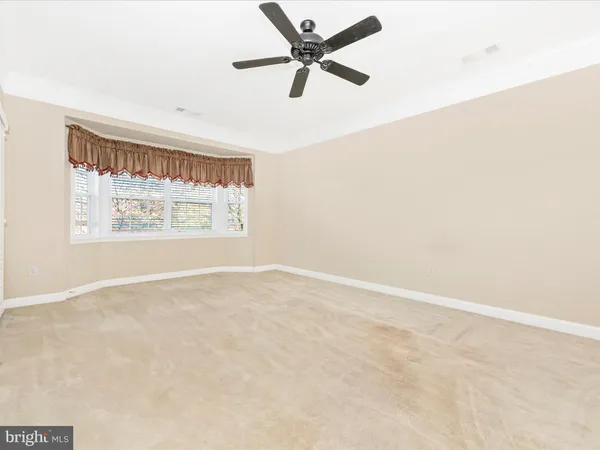 an empty room with a kitchen space and a window