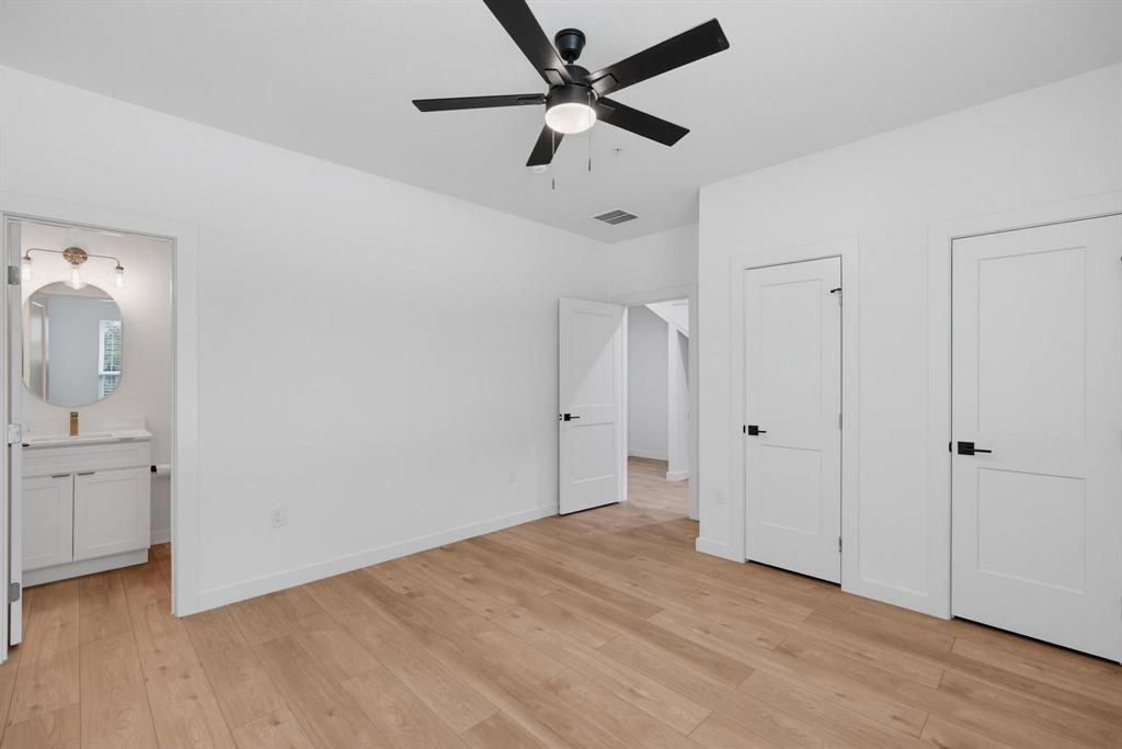 504 South O Connor Road Irving, TX 75060 - Photo 6 of 23 Bright room featuring wood-finish flooring, a modern black ceiling fan, and crisp white walls