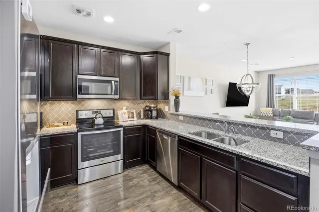 a kitchen with stainless steel appliances granite countertop a sink stove and refrigerator