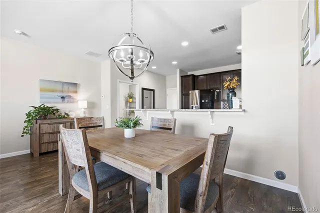 a view of a dining room with furniture a chandelier and wooden floor