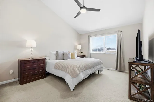 a bedroom with a bed and a flat tv screen on the dresser