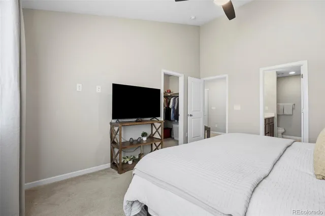 a bedroom with a bed and a flat tv screen on wall