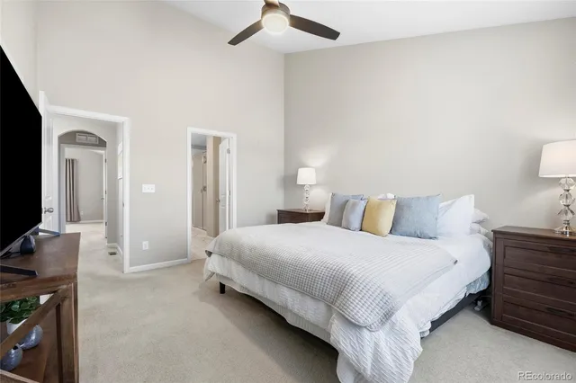 a bedroom with a bed and a flat tv screen on dresser