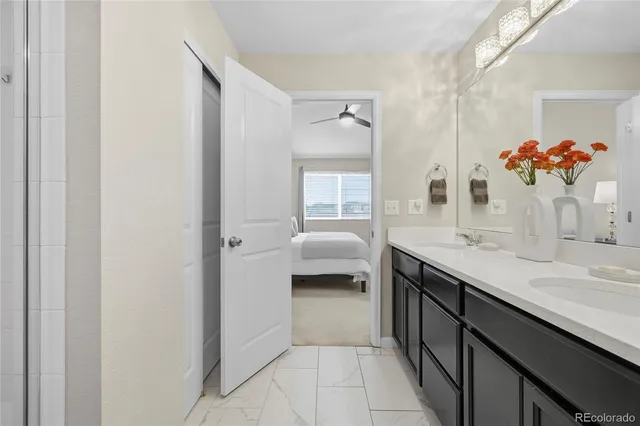 a en suite bathroom with a granite countertop sink a toilet and a mirror