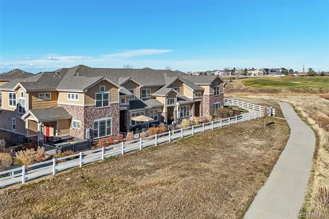an aerial view of residential houses with outdoor space and ocean view