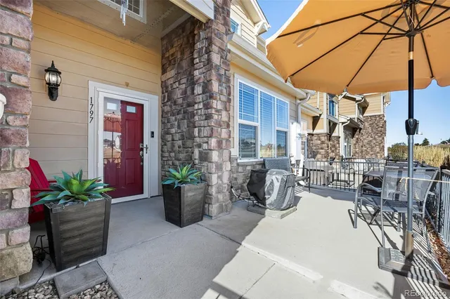 a view of a patio with dining table and chairs under an umbrella