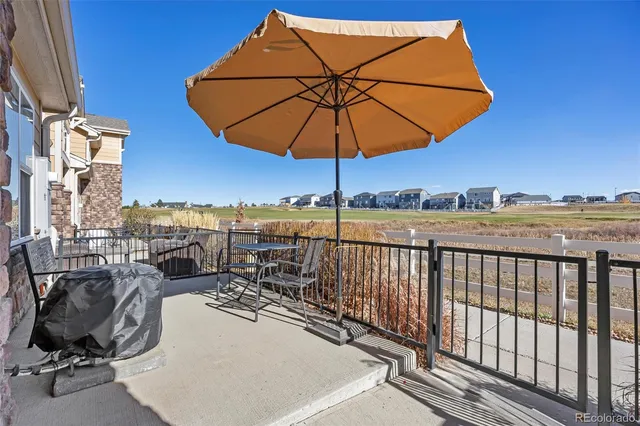 a view of a balcony with chairs and an umbrella