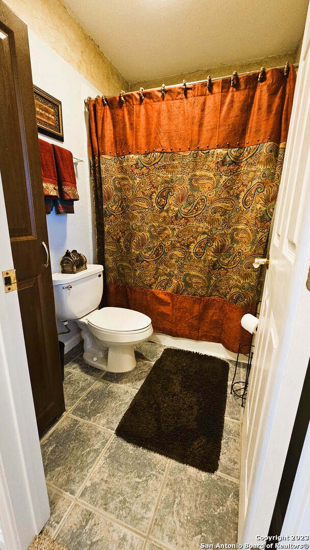 3245 Fm 470 Bandera, TX 78003 - Photo 56 of 58 a bathroom with a toilet and a shower curtain