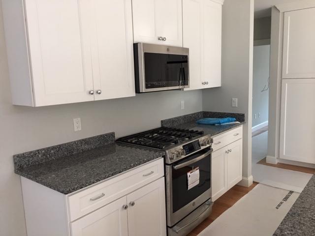 17 Alma Road Mashpee, MA 02649 - Photo 12 of 21 a kitchen with granite countertop white cabinets and stainless steel appliances