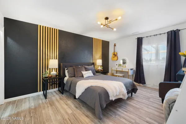 a bedroom with a bed lamp and a large window