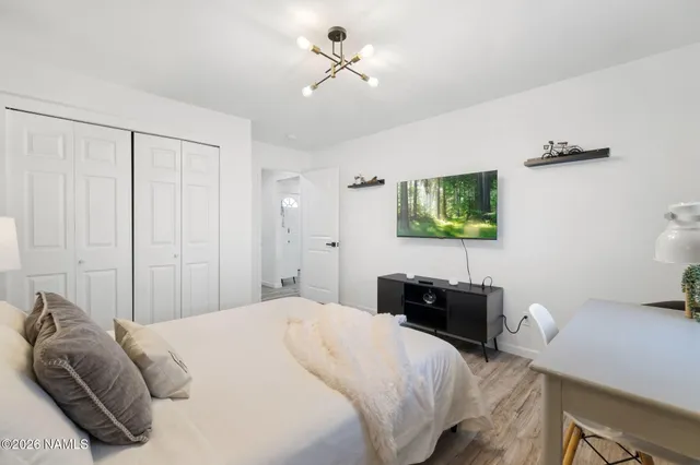 a bedroom with a bed and a chandelier