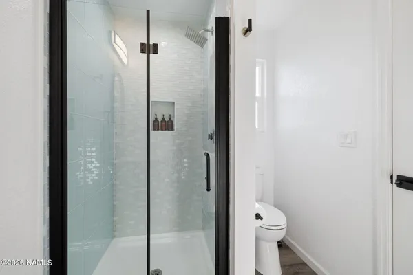 a bathroom with a toilet and a shower