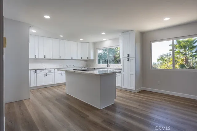 a kitchen with wooden floors and white cabinets