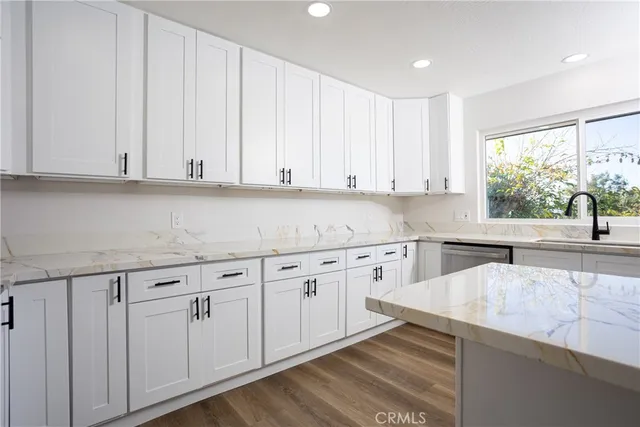 a kitchen with granite countertop white cabinets and sink