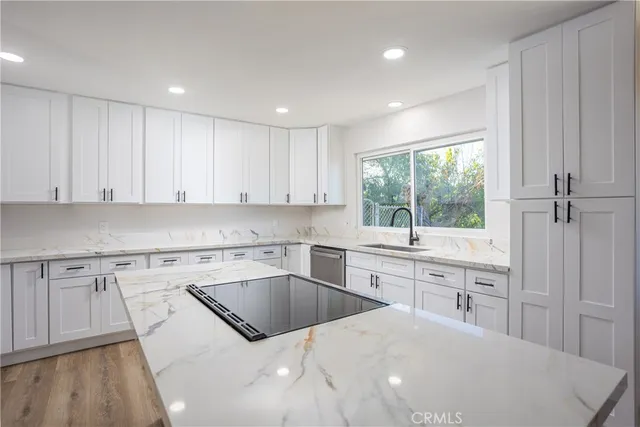 a kitchen with granite countertop white cabinets and white appliances