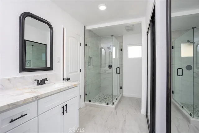 a bathroom with a double vanity sink mirror and shower
