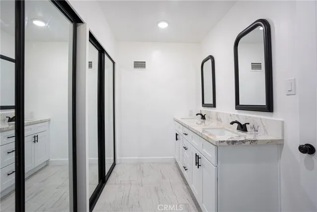 a bathroom with a double vanity sink and a mirror