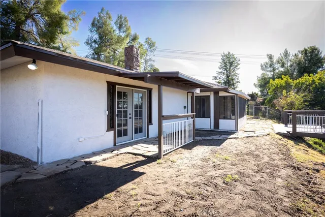 a view of a patio with table and chairs with wooden floor and fence
