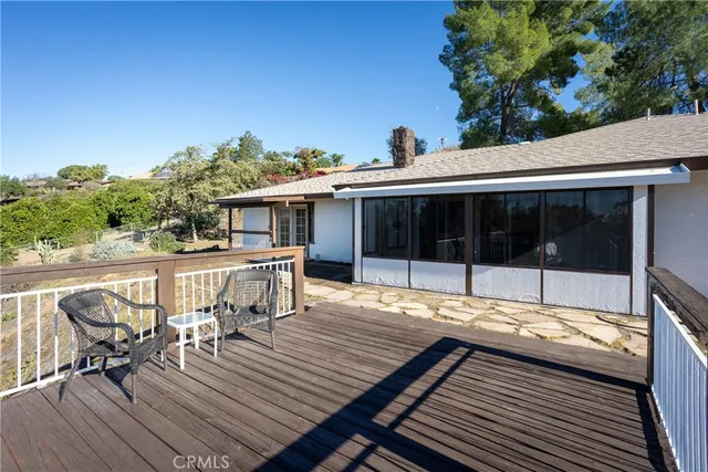 a view of a patio with table and chairs with wooden floor and fence