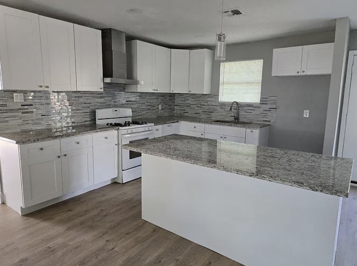 1902 Cleveland Street Pasadena, TX 77502 - Photo 2 of 6 a kitchen with stainless steel appliances granite countertop a sink a stove a refrigerator and cabinets