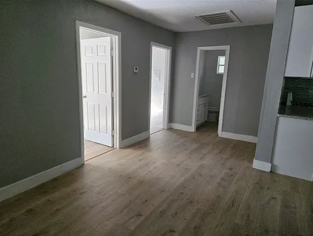 an empty room with wooden floor and closet