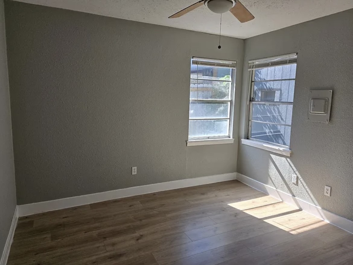 1902 Cleveland Street Pasadena, TX 77502 - Photo 4 of 6 an empty room with wooden floor and windows