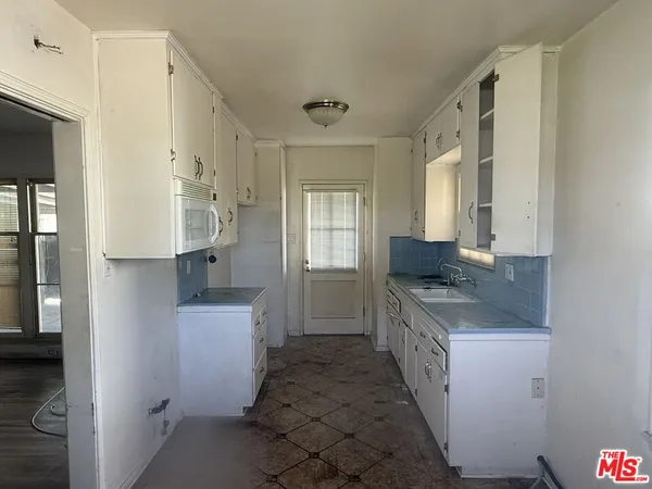 a bathroom with a granite countertop sink a mirror and a shower
