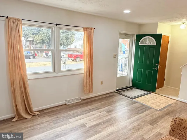 a view of an empty room with window and closet area