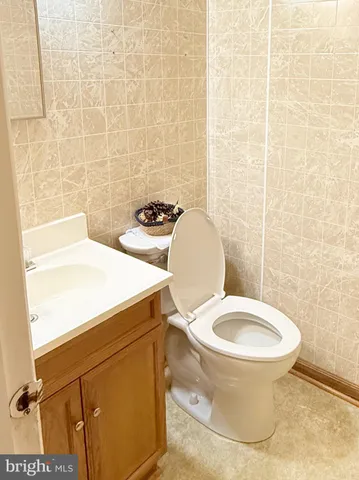 a white toilet sitting next to a white sink and a shower