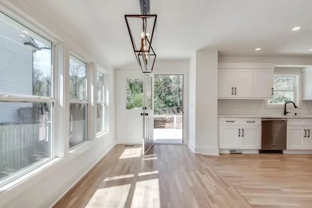 a open kitchen with white cabinets and a large window