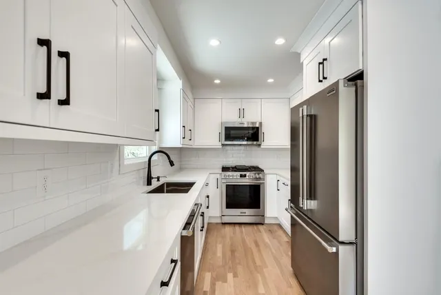 a kitchen with stainless steel appliances granite countertop a refrigerator sink and stove
