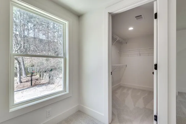 a spacious bedroom with a bed and wooden floor