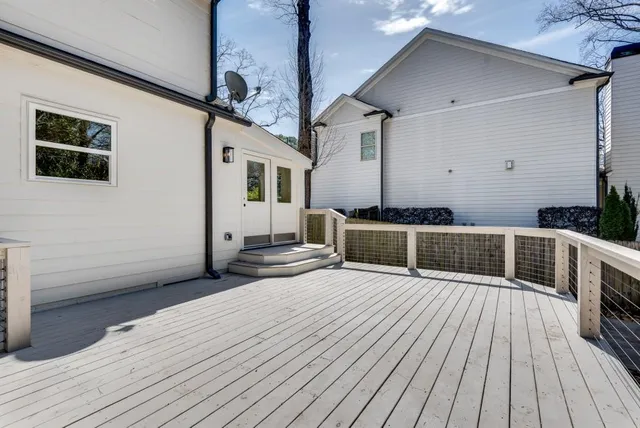 a view of a roof deck with couches and wooden fence