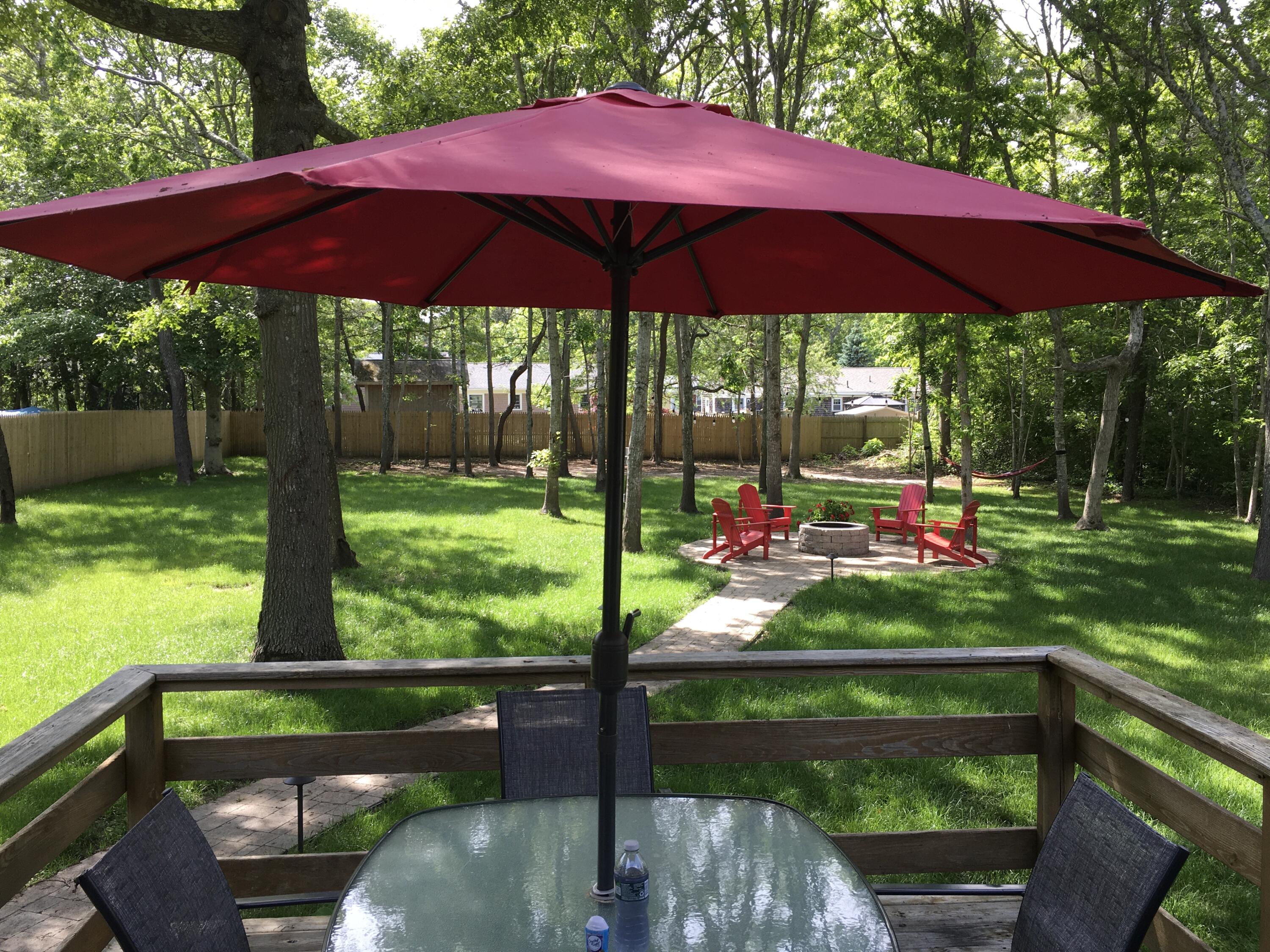 65 Kelley Road Hyannis, MA 02601 - Photo 24 of 38 a view of a wooden floor with a table and a chair under an umbrella