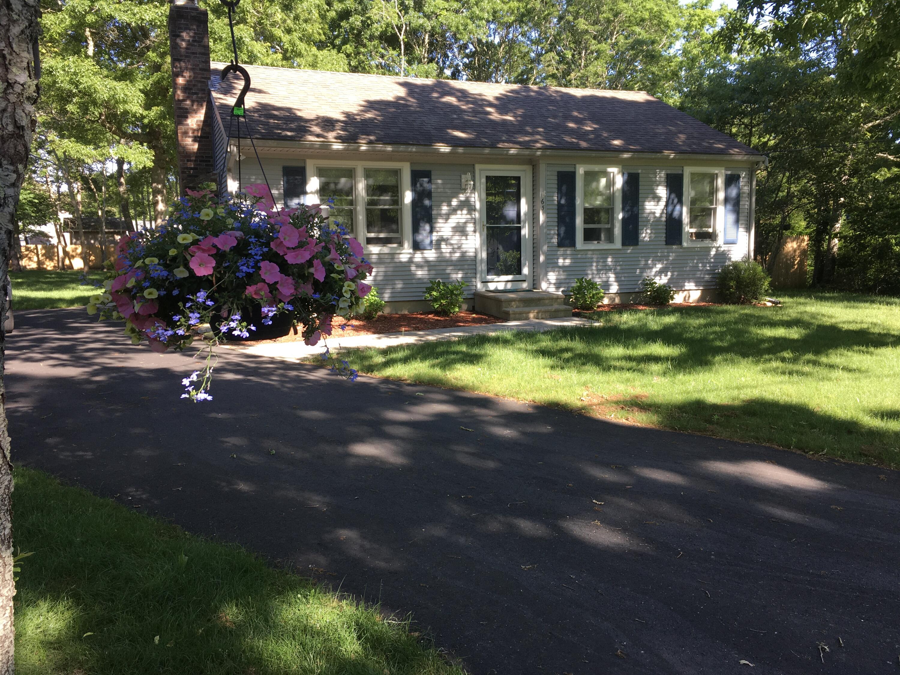 65 Kelley Road Hyannis, MA 02601 - Photo 3 of 38 a front view of a house with a yard garage and outdoor seating
