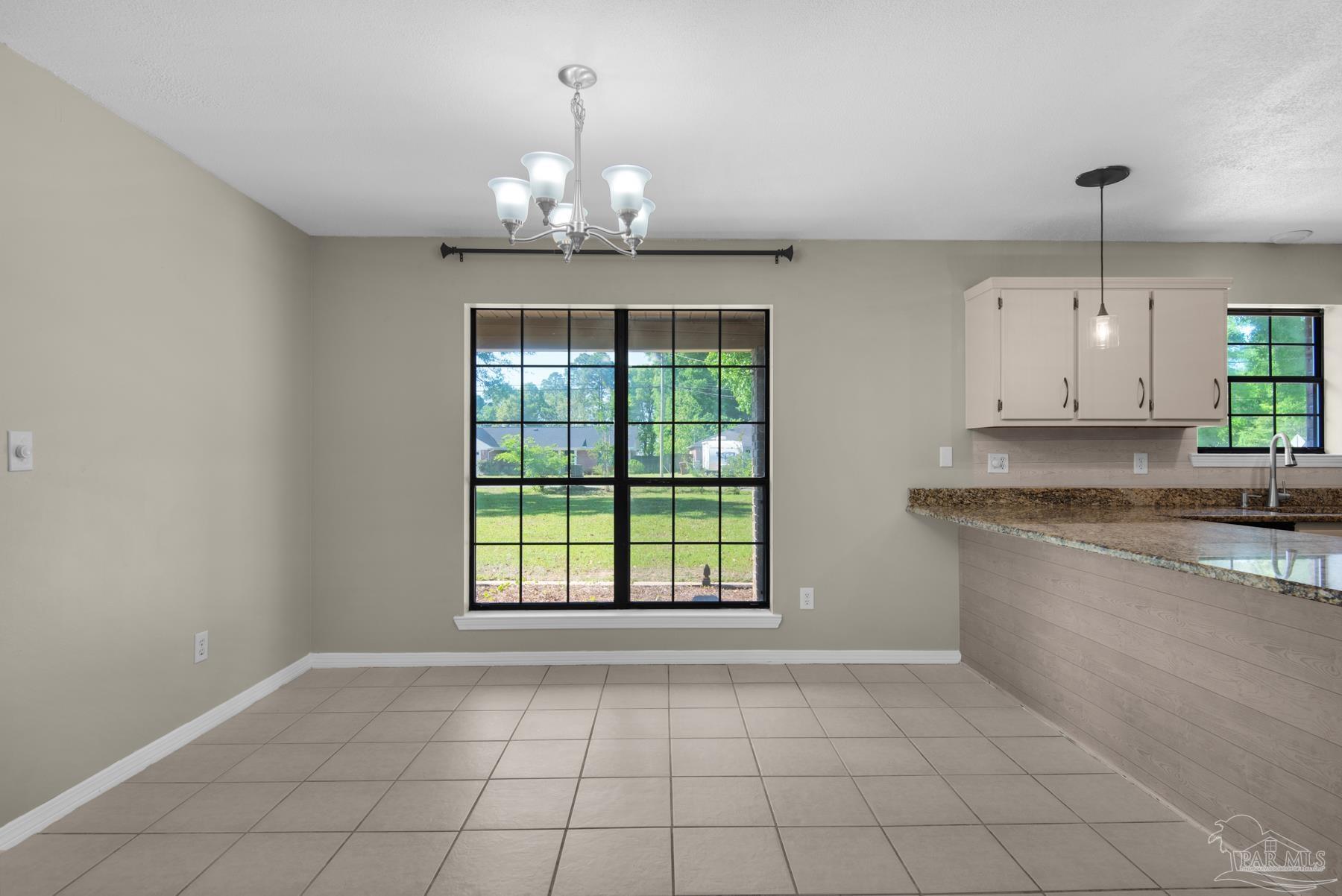 5804 Gulf Road Milton, FL 32583 - Photo 15 of 54 a view of a kitchen with granite countertop stainless steel appliances a sink stove and cabinets