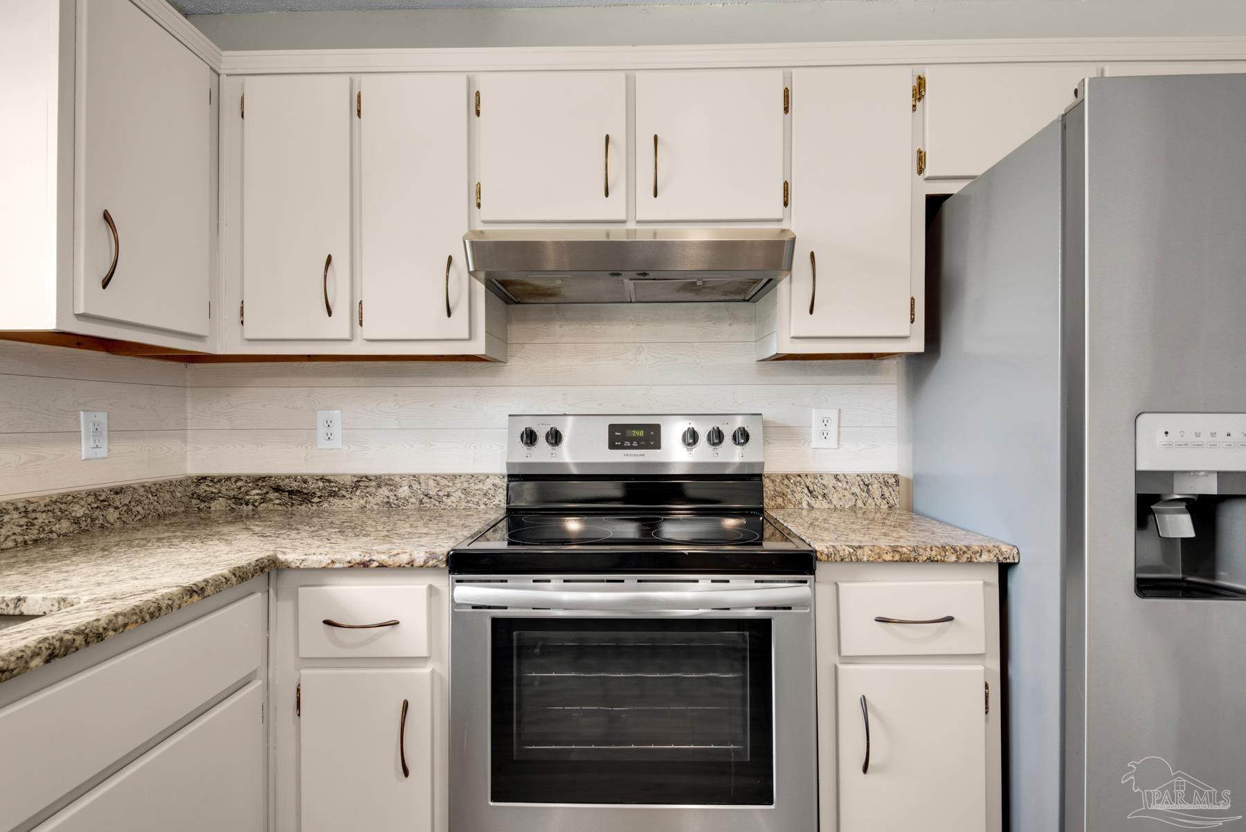 5804 Gulf Road Milton, FL 32583 - Photo 19 of 54 a kitchen with stainless steel appliances granite countertop white cabinets and a stove a oven with white countertops