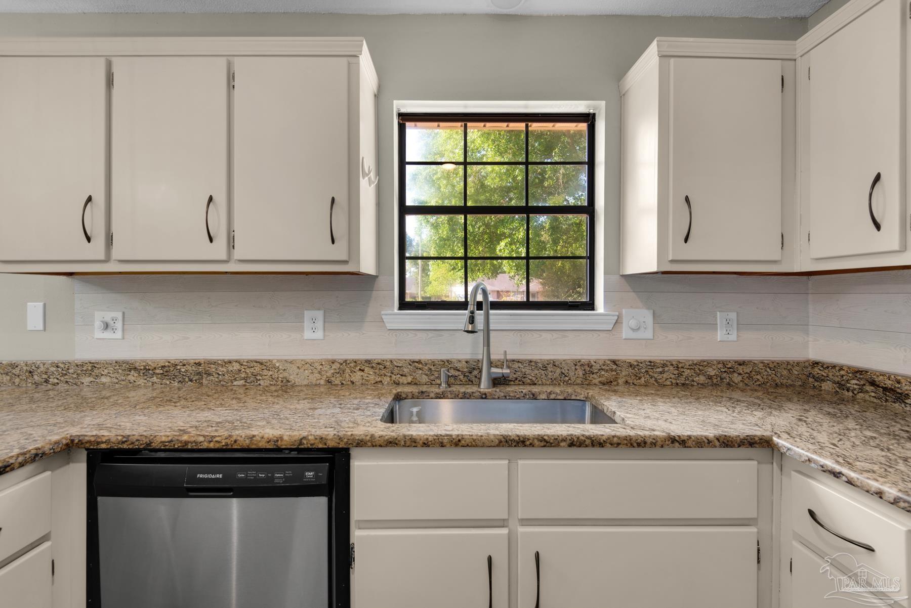 5804 Gulf Road Milton, FL 32583 - Photo 21 of 54 a kitchen with granite countertop white cabinets and a sink